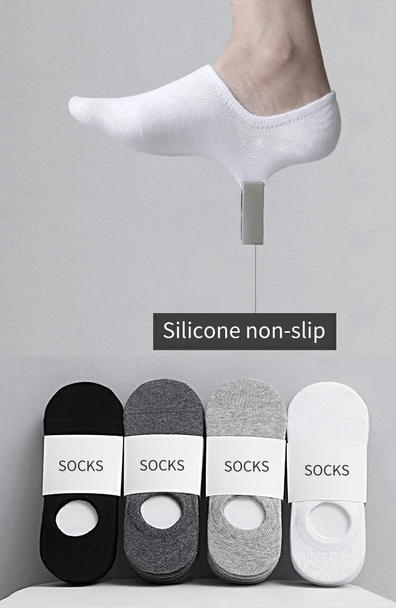 A set of white silicone non-slip no-show socks displayed next to a bare foot.