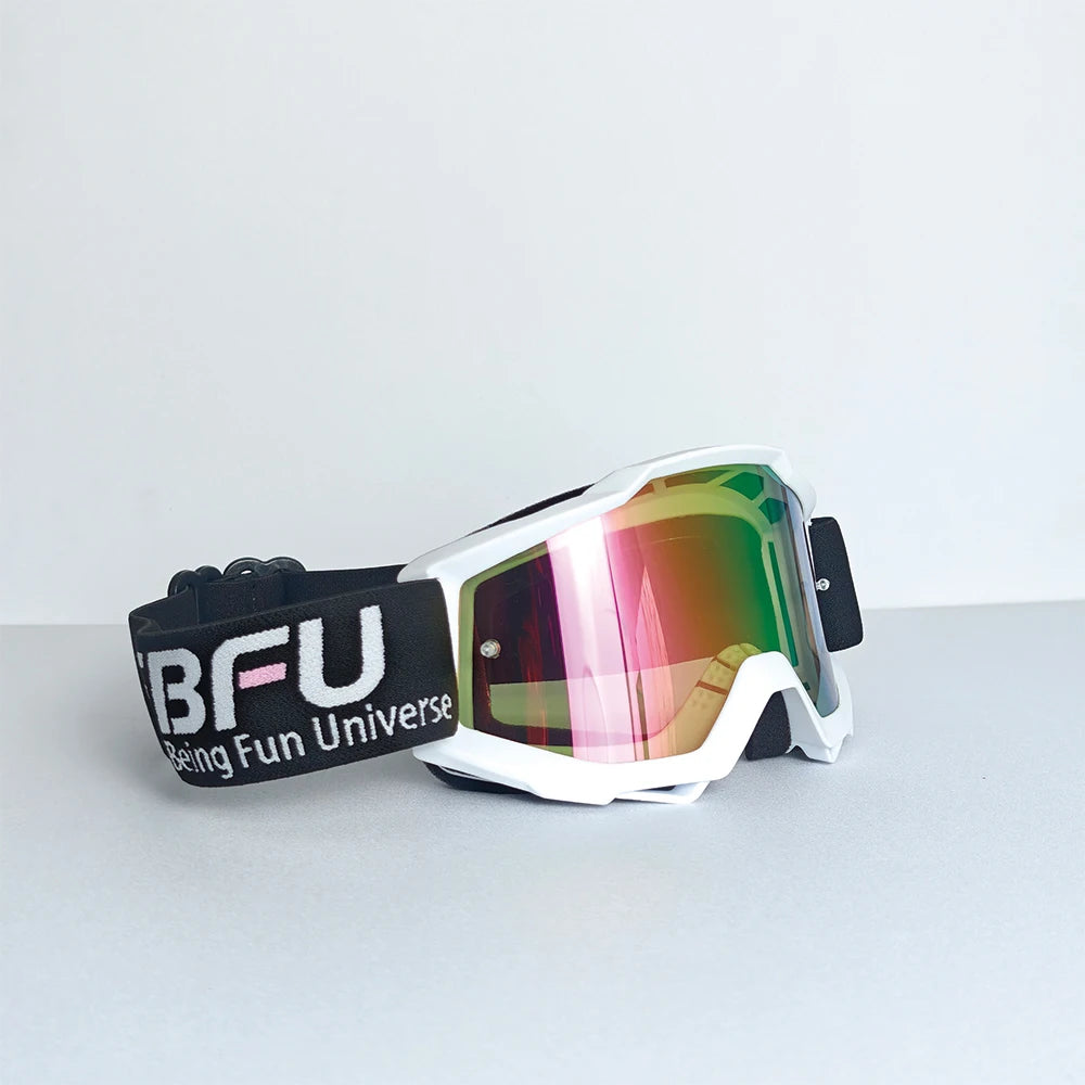 Black and white sport-grade skiing goggles with vibrant mirrored lenses resting on a gray surface.