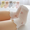 A display of three pairs of thin summer casual baby socks in various pastel colors and shades