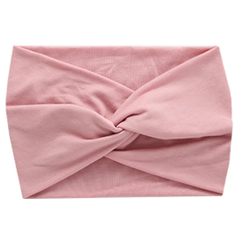A light pink women's elastic sports headband tied in a knot.
