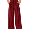 A model is wearing maroon flowy high waist drawstring wide leg pants with a white cropped top.