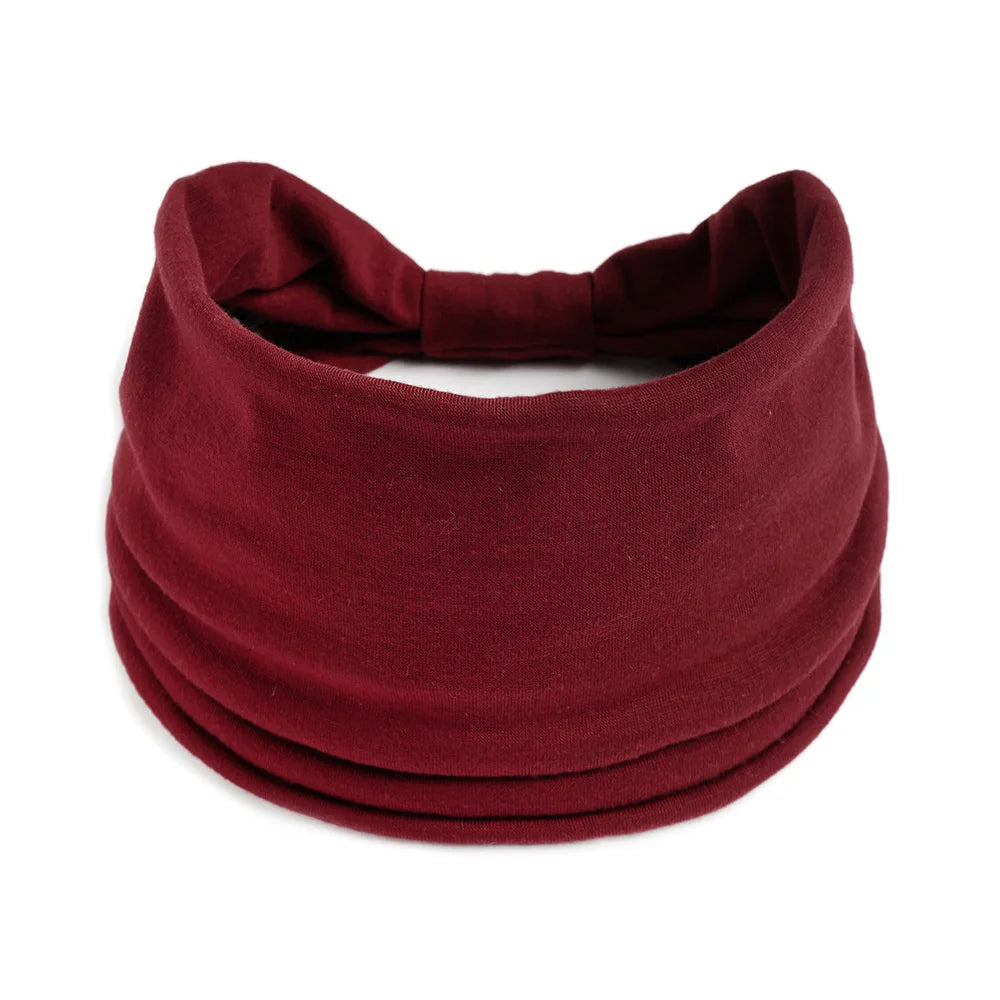 Un foulard ou turban en tissu marron, plié et exposé sur un fond blanc.