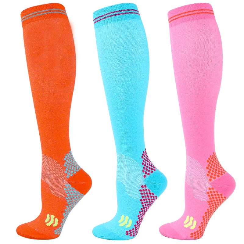 Three pairs of medical grade compression socks in orange, blue, and pink showing different colors.
