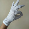 Una mano con guantes de algodón blancos haciendo un gesto con los dedos.