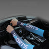 A person wearing blue sports sleeves is driving a car, with the steering wheel and dashboard visible.