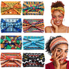 A collection of colorful boho cotton turban headbands worn by a woman, showcasing various patterns and styles.