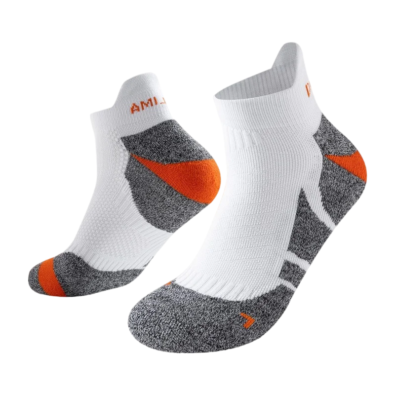 A pair of white performance sports ankle socks with gray and orange accents.