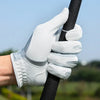 A hand wearing a white golf glove grips a black golf club shaft outdoors.