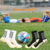 Ein Vierer-Set weiße rutschfeste Sportsocken auf grünem Gras.