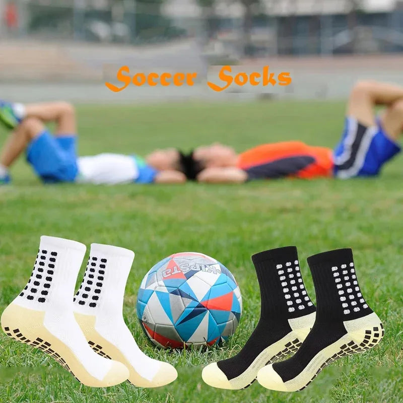 Ein Vierer-Set weiße rutschfeste Sportsocken auf grünem Gras.
