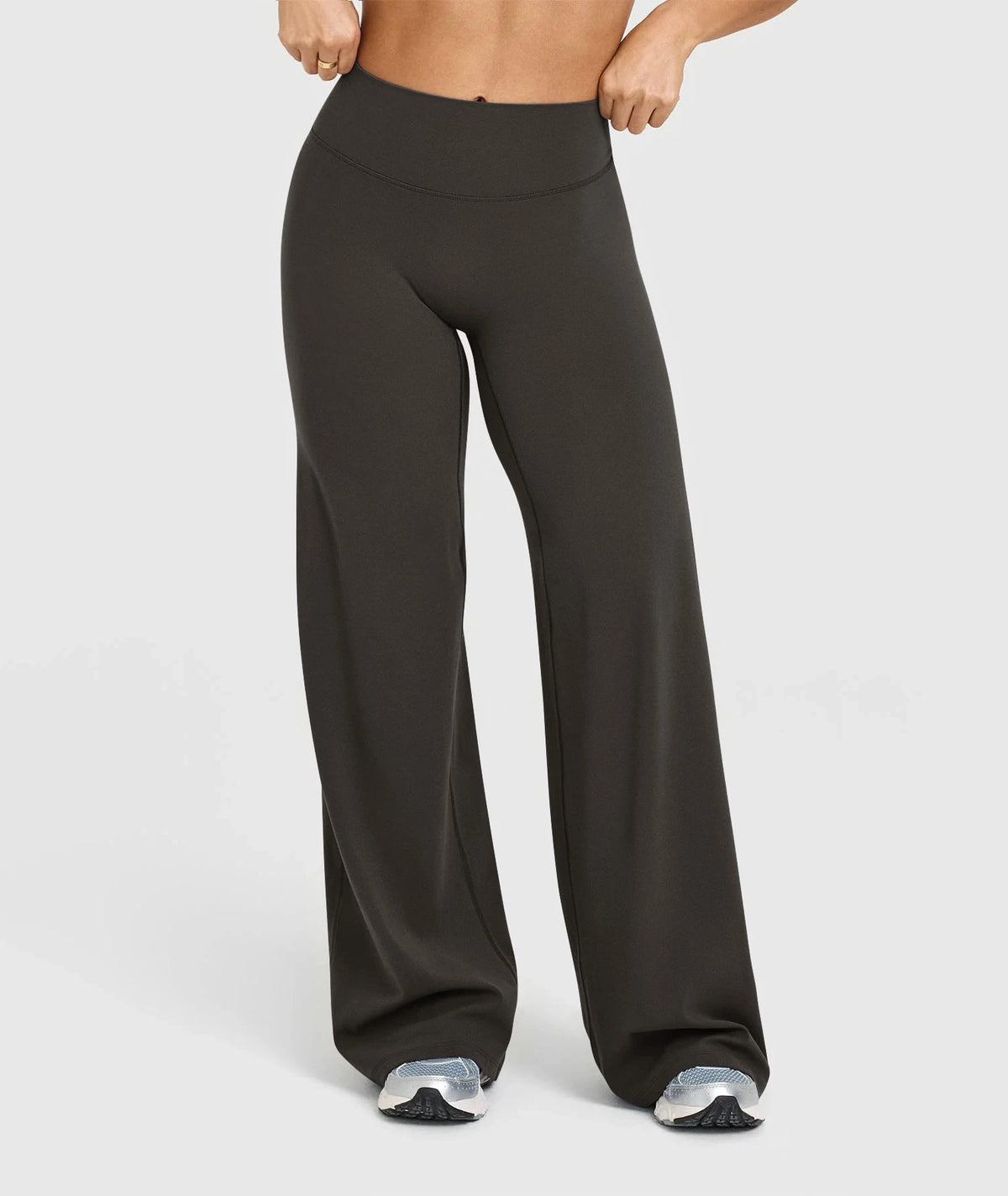 A pair of dark gray high waisted wide leg yoga pants being worn by a person.
