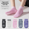 A set of pink yoga socks with silicone anti-slip grips shown on a person's foot.