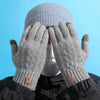 A pair of light gray knitted winter gloves covering a person's head.