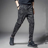 Men's camouflage elastic waist drawstring pants in dark gray fabric shown on a model.
