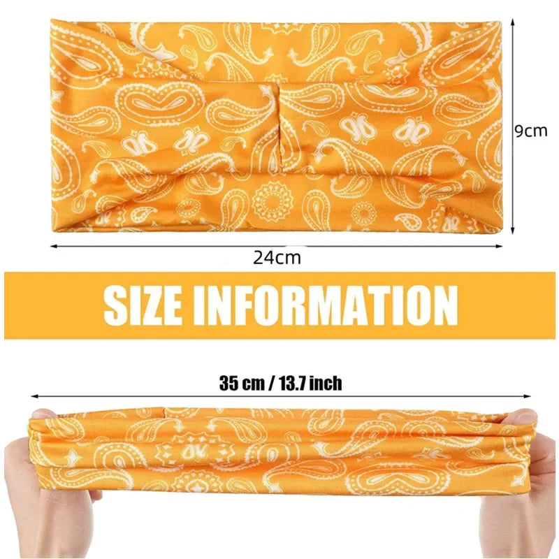 Orange paisley patterned sports headband shown flat and being held by a hand