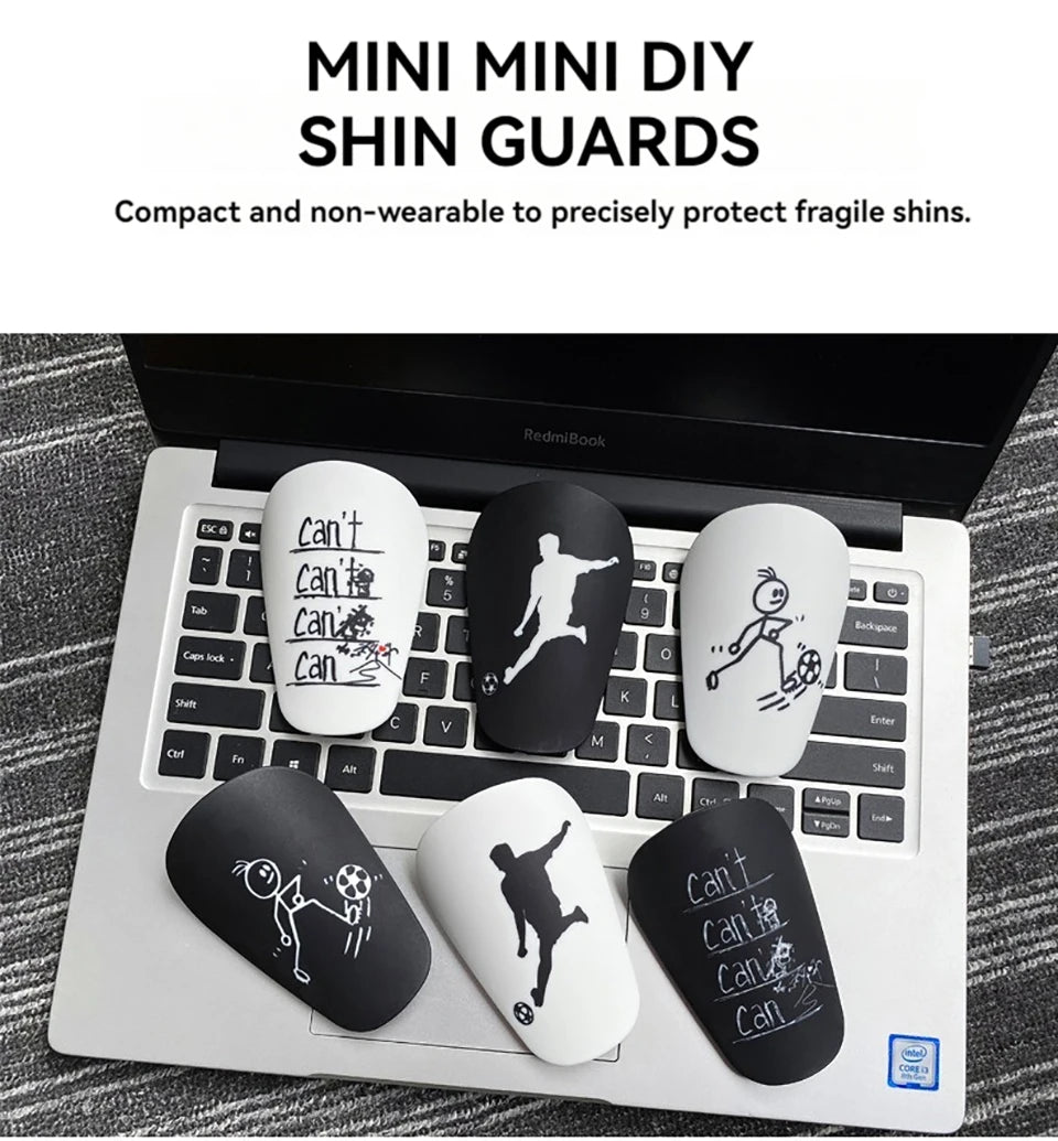 A set of mini DIY shin guards featuring silhouettes of soccer players and sports figures placed on a laptop keyboard.