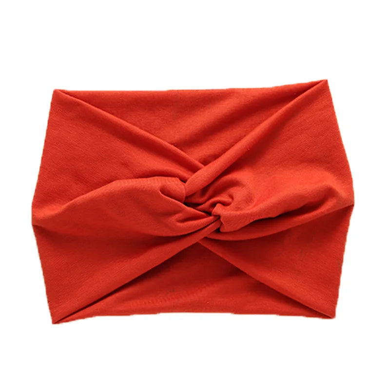 A folded orange women's elastic sports headband.