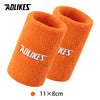 Pair of bright orange silicone sport wristbands shown next to a size measurement.