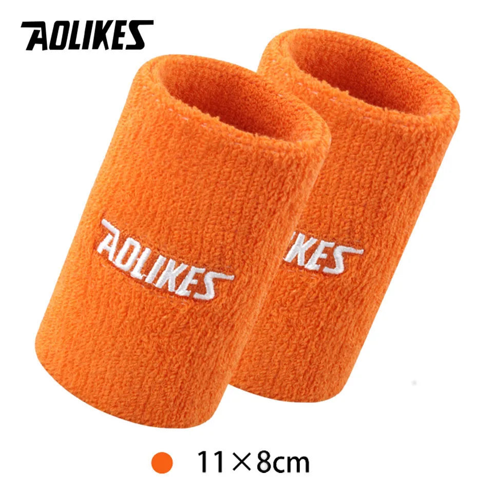 Pair of bright orange silicone sport wristbands shown next to a size measurement.