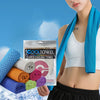 Une femme tient un paquet de serviettes super-refroidissantes Cooltowel de différentes couleurs contre un ciel bleu.