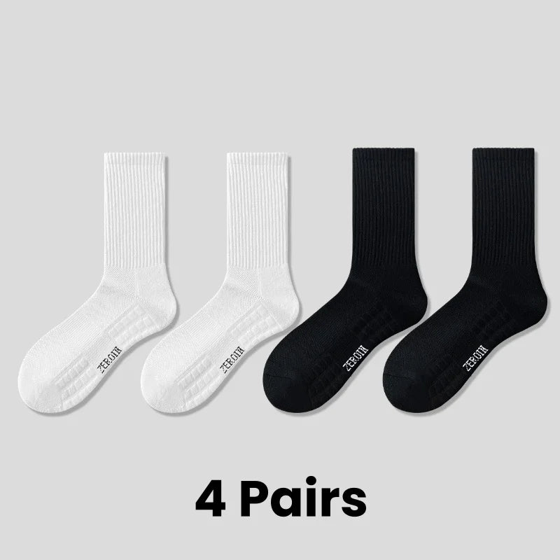 Four pairs of black and white breathable sports performance socks displayed side by side.
