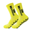 A pair of bright yellow anti-slip performance sports socks with black text and grip dots.