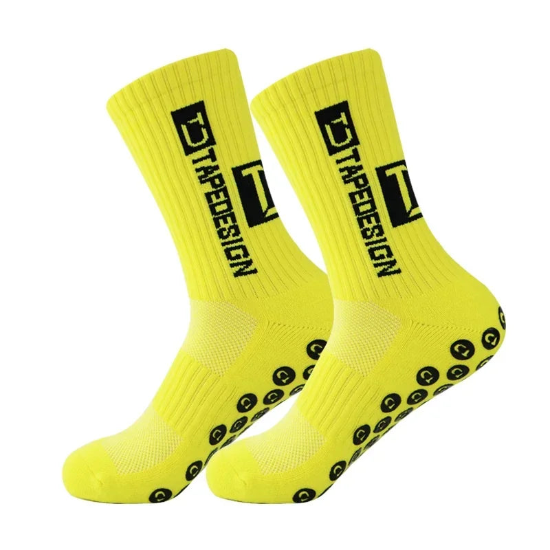 A pair of bright yellow anti-slip performance sports socks with black text and grip dots.