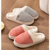 A set of cozy plush fleece slippers in beige, gray, and pink are displayed on a wooden floor.