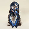 A dark blue satin square scarf featuring intricate silver and gold embroidery for hijab or hair