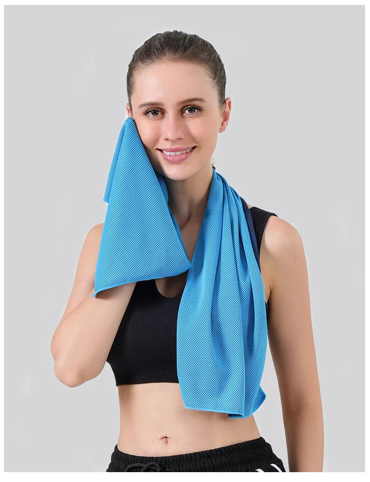 A woman wearing a black sports top holds up a bright blue instant cooling towel.