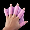 A hand is holding a pink silicone swim training flipper, showing the product's texture and shape.