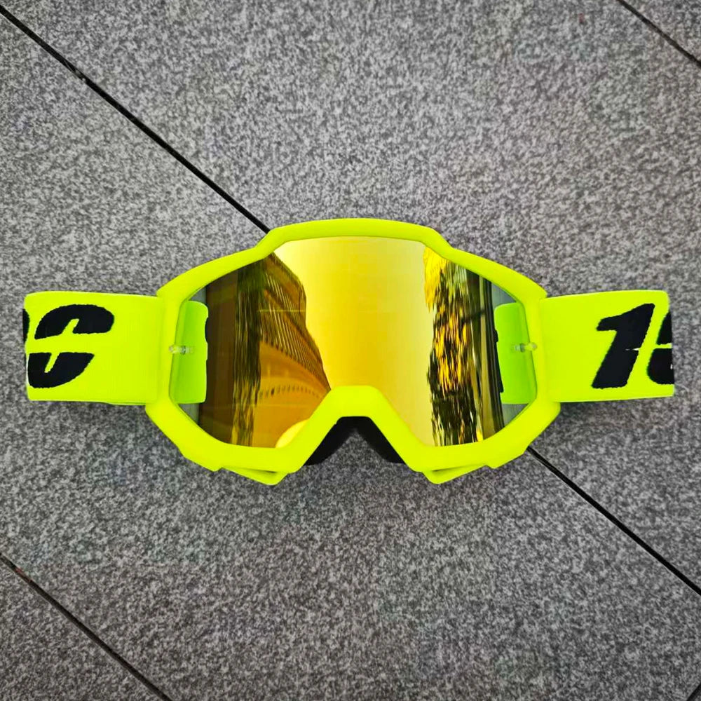 Une paire de lunettes de moto et d'ATV jaune vif posées sur une surface gris foncé.