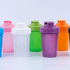 A row of colorful portable protein shaker bottles in various shades including blue, pink, white, green, purple, and orange.