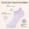 A close-up view of white Pilates grip socks for women showing features like a heel tab, mesh design, and elastic arch support