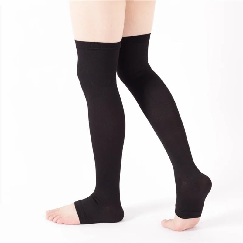 Black unisex compression thigh high socks worn on a person's legs.