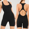 A model wearing a black, fitted, backless fitness jumpsuit.