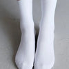 Une paire de chaussettes en tricot blanches mi-mollet respirantes, montrées sur un fond clair.