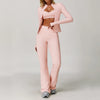A woman models a pink 3-piece yoga sports set consisting of a cropped top, blazer, and matching pants.