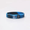 A dark blue silicone wristband with the number 11 and a signature etched on the surface.