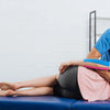 A man applies professional kinesiology tape to a woman's arm during athletic recovery.