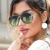 A woman wearing classic double-bridge aviator sunglasses with gold accents and a large white teardrop earring.