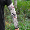 Close-up of a person's arm wearing a black long sleeve shirt, displaying an intricate black and white tattoo sleeve.