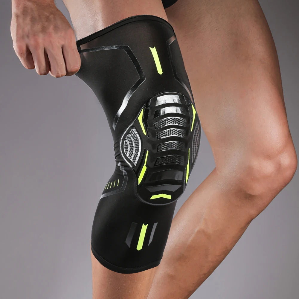 A black compression knee brace with neon yellow accents is worn on a person's leg.