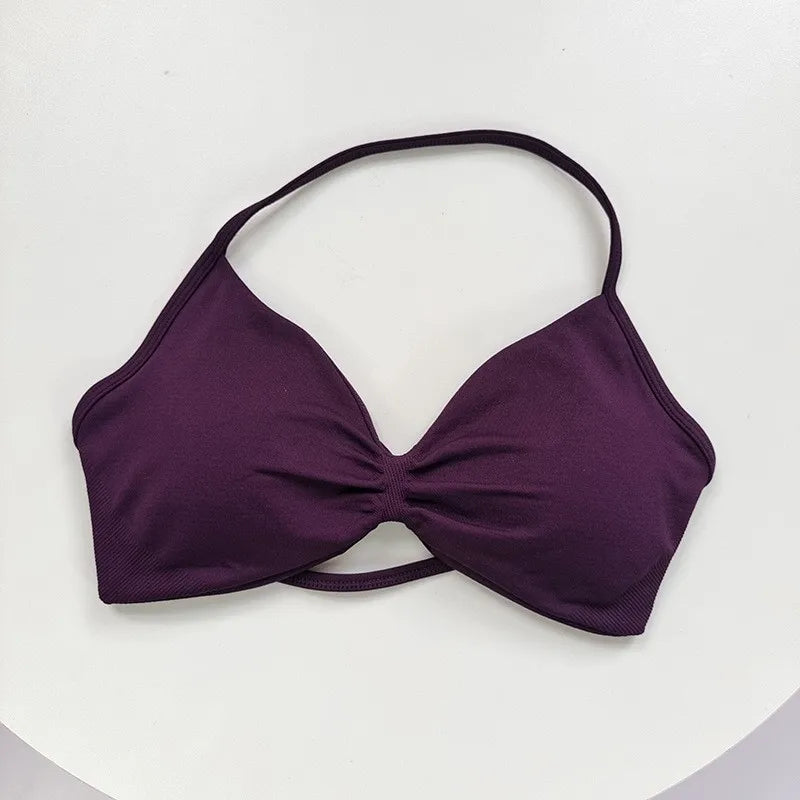 Sujetador deportivo morado intenso con diseño de cordones, mostrado sobre fondo blanco.