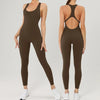A woman models a dark olive green backless fitness jumpsuit.