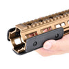 A hand holds a tactical rail panel kit for an airsoft gun, featuring a bronze-colored rail and black grip.