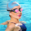 A woman wearing professional anti-fog swimming goggles and a light blue cap in clear blue water.