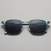 Teal-green metal frame sunglasses with dark lenses displayed against a light gray background.