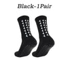 A pair of black multi-sport athletic grip socks shown from the side.