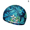 Bonnet de bain en nylon élastique bleu foncé et sarcelle à motifs de feuilles tropicales.